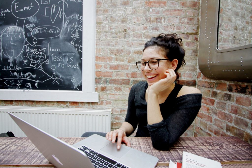 Woman Smiling while Using Laptop